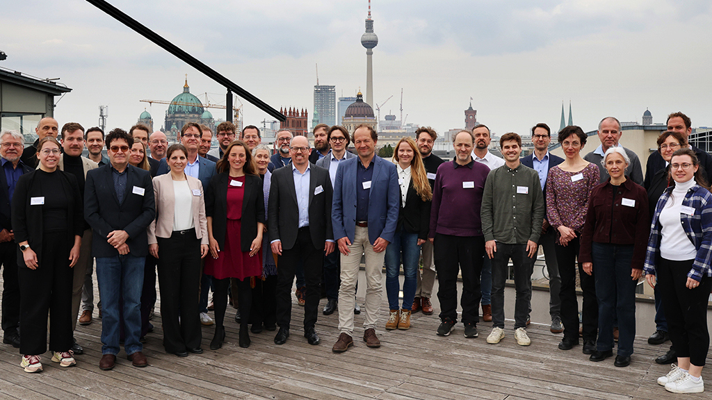 Gruppe Menschen auf einer Dachterrasse, Städteziel im Hintergrund.